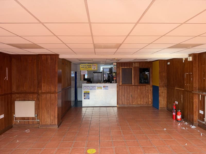 Before: a cafeteria with dark varnished wood panelling, red tiled floor and a serving counter