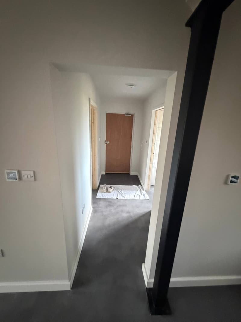 Hallway with crisp white walls and a black steel column