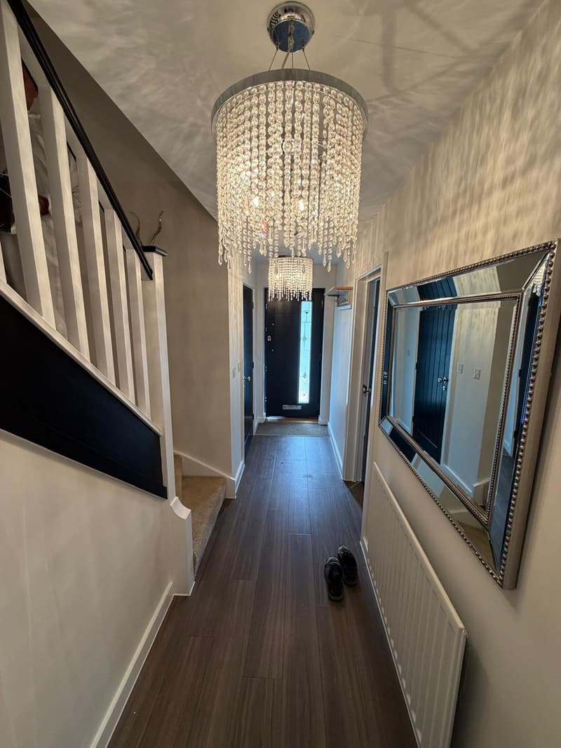 Hallway with black banister and panelled doors