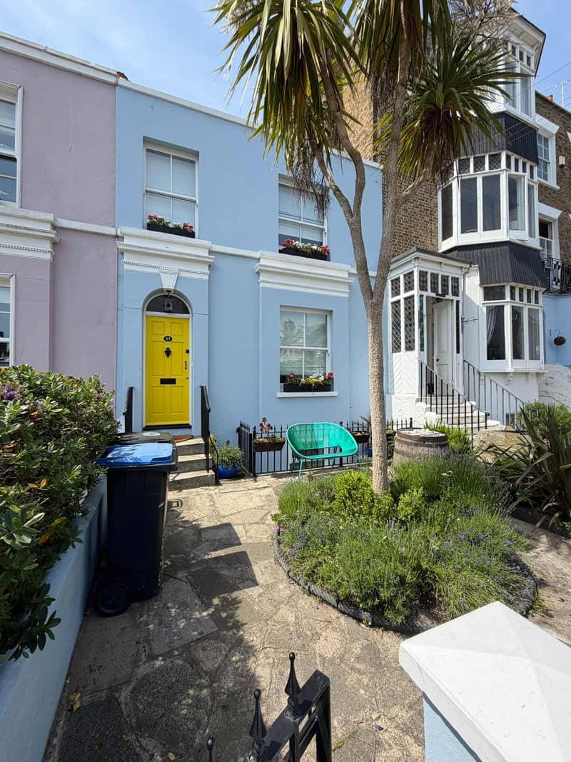 Powder blue render, white surrounds and a yellow front door